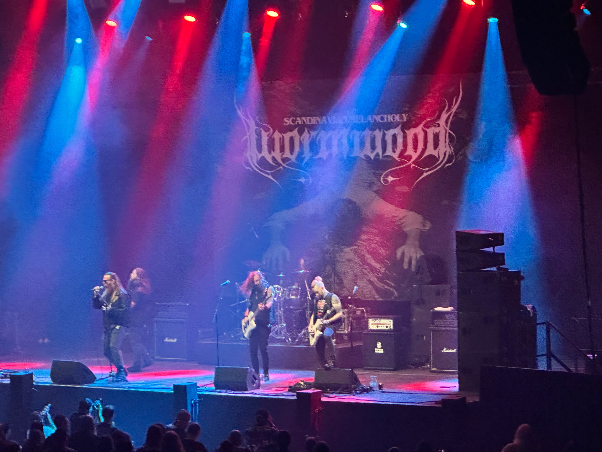 Wormwood — Scandinavian melancholy opens Day One. Wormwood performing at Hellsinki Metal Festival 2026 in red and blue stage light with their Scandinavian Melancholy backdrop