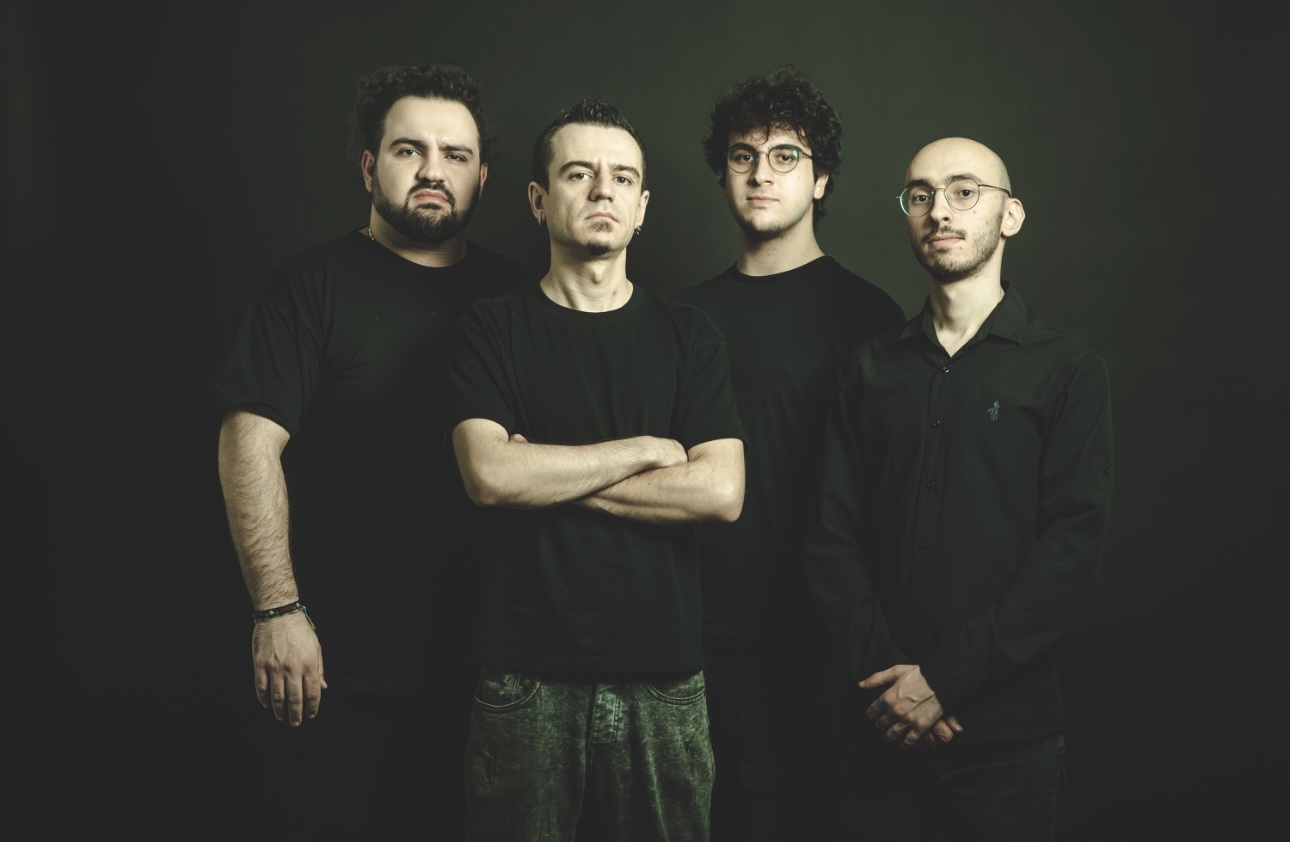 The four members of Lebanese heavy metal band Nuwera standing together in black clothing against a dark green backdrop
