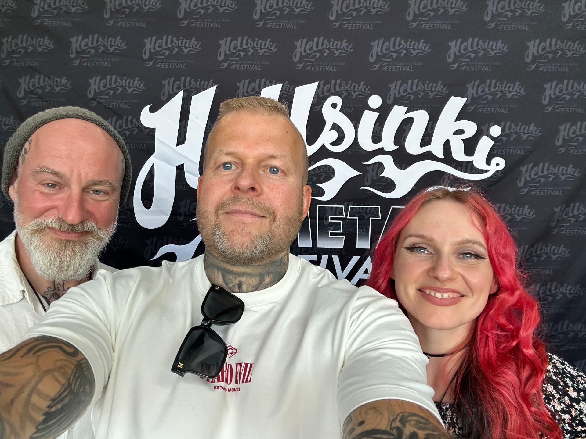 Backstage interview — Eluveitie. Tomi Perrakoski backstage with members of Eluveitie in front of the Hellsinki Metal Festival 2026 backdrop