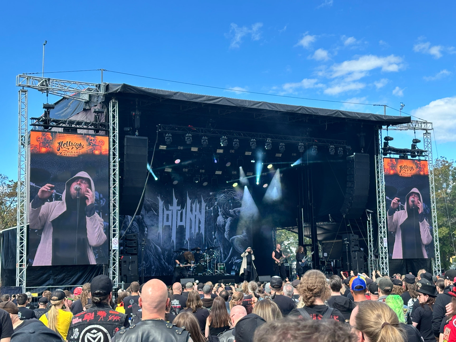 Iotunn — the progressive highlight of the day. Iotunn performing at Hellsinki Metal Festival 2026 in the afternoon sun with their monochrome backdrop and a packed crowd