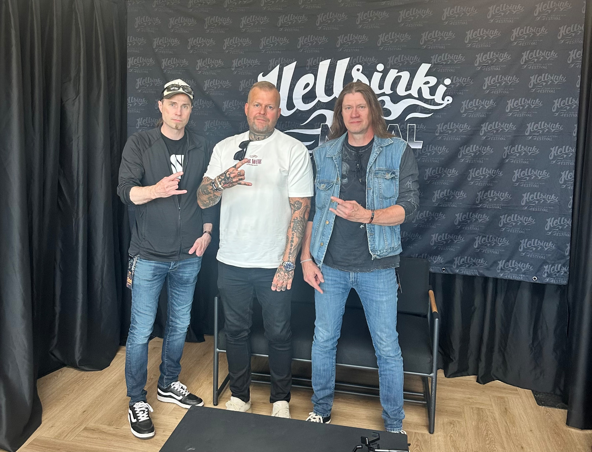 Backstage interview — Kalmah. Tomi Perrakoski backstage with members of Kalmah in front of the Hellsinki Metal Festival 2026 backdrop