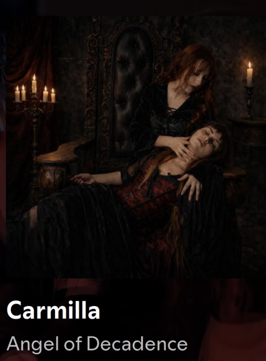 Angel of Decadence — Carmilla single cover, gothic scene of a red-haired vampire embracing a fainting woman by candlelight